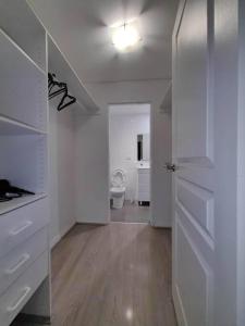 a room with a bathroom with a toilet and a door at Entire 3 bed apartment in Ryde in Sydney