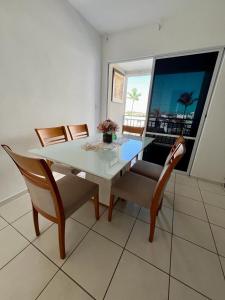 a dining room with a table and chairs and a window at Apartamento Clube 3/4 com Ar-condicionado in Aracaju