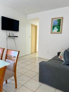 - un salon avec un canapé et une table dans l'établissement Apartamento Clube 3/4 com Ar-condicionado, à Aracaju