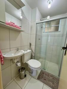 a bathroom with a toilet and a sink and a shower at Apartamento Clube 3/4 com Ar-condicionado in Aracaju