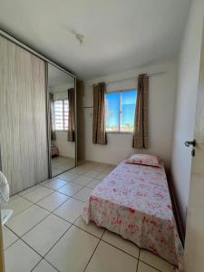 a bedroom with a bed and a large window at Apartamento Clube 3/4 com Ar-condicionado in Aracaju