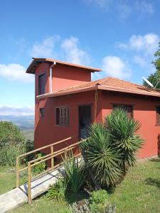czerwony dom na szczycie wzgórza w obiekcie Chalé Panorâmico w mieście Ouro Preto