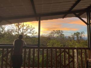 a man standing on a porch looking at the sunset at Waka Maru in San Agustín