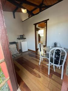 a dining room with a table and chairs and a kitchen at Chalé Panorâmico in Ouro Preto