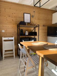 ラ・プラーニュにあるAppartement au pied des pistesの木製の壁、テーブルと椅子が備わる客室です。