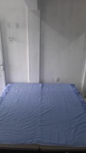 a bed in a bedroom with a blue bedspread at Residencial Praia Quente casas in Nova Viçosa