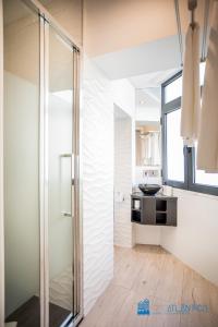 een badkamer met een glazen douche en een wastafel bij Porto Formosa Central Lofts in Porto +62 foto's