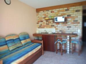 a room with a bed and a kitchen with a counter at Estalagem Capitão Gancho in Praia do Rosa