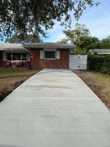 a driveway in front of a brick house at Cozy private studio w/own yard - 3mi from Beach in Seminole