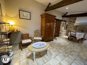 a living room with a table and chairs and a fireplace at Gîte charmant à la campagne avec terrasse, proche du Puy du Fou et de la rivière Sèvre - FR-1-426-249 in Sevremont +10 photos
