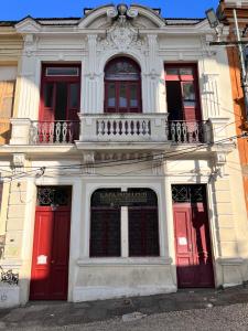 a white building with red doors and windows at Arcos Da Lapa Hostel in Rio de Janeiro