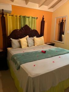 a bedroom with a large bed with red flowers on it at Epic Paradise in Ocho Rios