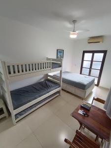 a living room with two bunk beds and a table at Flat Maresias 50m da Praia - 02 Mar & Tur in Maresias