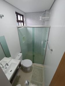 y baño con ducha, aseo y lavamanos. en Flat Maresias 50m da Praia - 02 Mar & Tur en Maresias