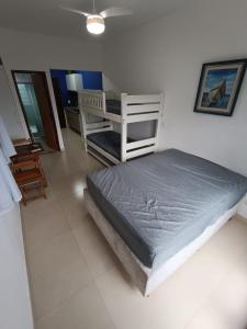 a bedroom with a bed and a chair in it at Flat Maresias 50m da Praia - 02 Mar & Tur in Maresias