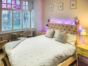 ein Schlafzimmer mit einem großen Bett mit rosa Lichtern in der Unterkunft Mulgrave House in Scarborough
