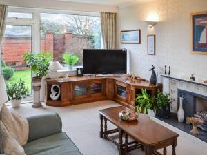 a living room with a television and a fireplace at Kempton House in Lincoln