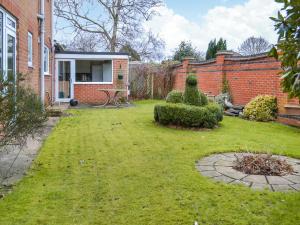 a yard with a brick house and a table and bushes at Kempton House in Lincoln