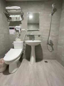 a bathroom with a toilet and a sink at 溫情自助旅店 in Taoyuan