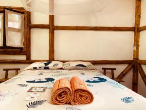 a bed with two towels on top of it at La Caleta in Mompiche