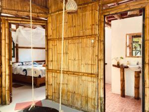 baño con pared de madera y cama en La Caleta, en Mompiche