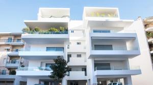a white apartment building with balconies on it at White luxury apartment in Tríkala