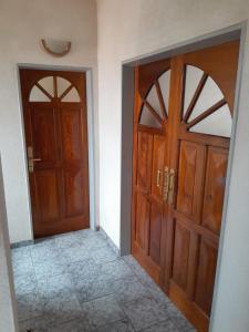 2 puertas de madera en una habitación con suelo de baldosa en Departamento La Plaza en La Falda