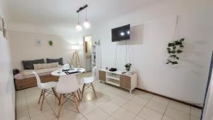 1 dormitorio y sala de estar con mesa y sillas. en La Quinta departamento en Mendoza