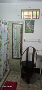 a bathroom with a chair in front of a mirror at Tortuguero Casa de Playa Green House in Tortuguero