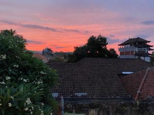 een uitzicht op een dak van een huis bij zonsondergang bij Kubu Elsa Bali in Lovina