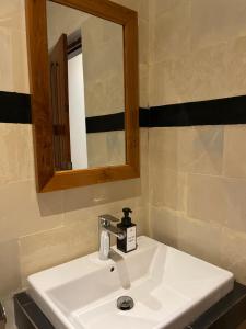 lavabo blanco en el baño con espejo en Kubu Elsa Bali, en Lovina