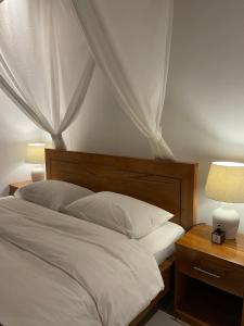 羅威那的住宿－Kubu Elsa Bali，卧室配有带两盏灯的白色床