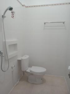 y baño blanco con aseo y ducha. en Chiinta House, en Ubud