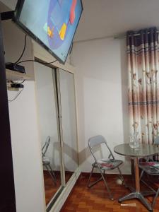 una camera con tavolo, due sedie e una TV di Bello y acogedora casa -departamento habitaciones a Lima