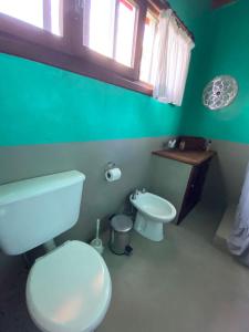a green bathroom with a toilet and a sink at Casa Rose Chapadmalal in Mar del Plata