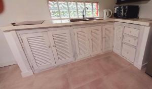 a kitchen with white cabinets and a sink and a window at Casa Rose Chapadmalal in Mar del Plata