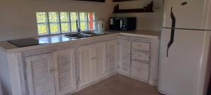 a kitchen with white cabinets and a white refrigerator at Casa Rose Chapadmalal in Mar del Plata