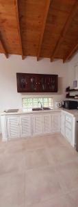 a large kitchen with white cabinets and wooden ceilings at Casa Rose Chapadmalal in Mar del Plata +20 photos