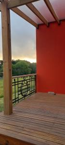 a wooden deck with a red wall and a fence at Casa Rose Chapadmalal in Mar del Plata