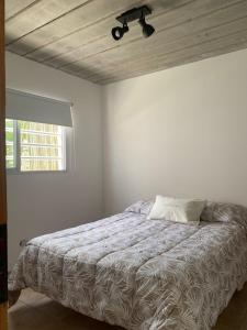 1 dormitorio con 1 cama y ventilador de techo en Casa Monte hermoso a media cuadra Del Mar en Monte Hermoso