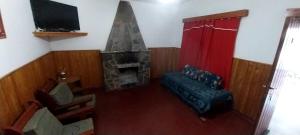 sala de estar con sofá y chimenea en ARROYO SERRANO-MINA CLAVERO en Mina Clavero