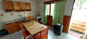 eine kleine Küche mit einem Tisch und einer Küche sidx sidx sidx in der Unterkunft ARROYO SERRANO-MINA CLAVERO in Mina Clavero