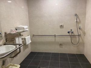 ein Bad mit einer Dusche und einem Waschbecken in der Unterkunft Emperor Hotel in Taipeh