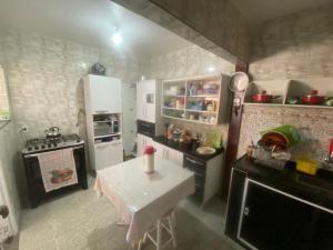 una piccola cucina con tavolo e piano cottura di Casa Arraial ad Arraial do Cabo