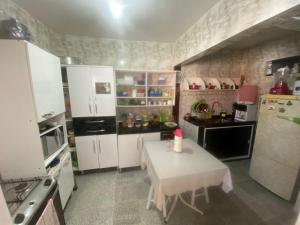 una cucina con tavolino e tavolino bianco sidx sidx sidx di Casa Arraial ad Arraial do Cabo