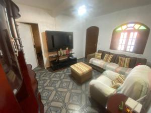 un soggiorno con divano e TV a schermo piatto di Casa Arraial ad Arraial do Cabo