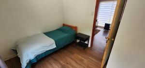 1 dormitorio con 1 cama y puerta que da a un pasillo en Cabaña 4 persona Maitencillo, en Maitencillo