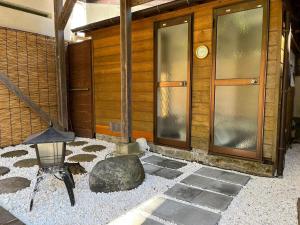 Fuji-Hakone Guest House في هاكوني: مبنى فيه صخرة ومظلة أمامه