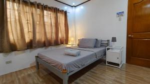 a bedroom with a bed and a window at Ormoc Mountain View Retreat in Ormoc