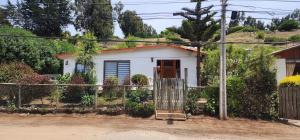 una pequeña casa blanca con una puerta delante en Cabaña 4 persona Maitencillo, en Maitencillo